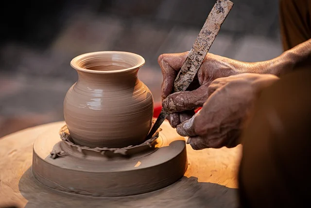 Artisan shaping clay on pottery wheel